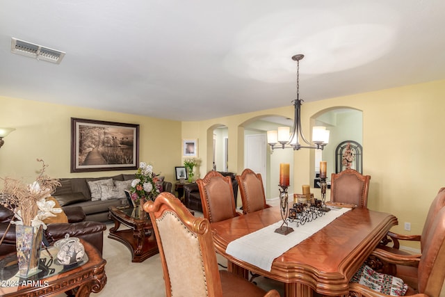 carpeted dining area featuring a chandelier