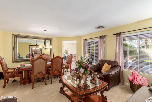 carpeted living room with a notable chandelier