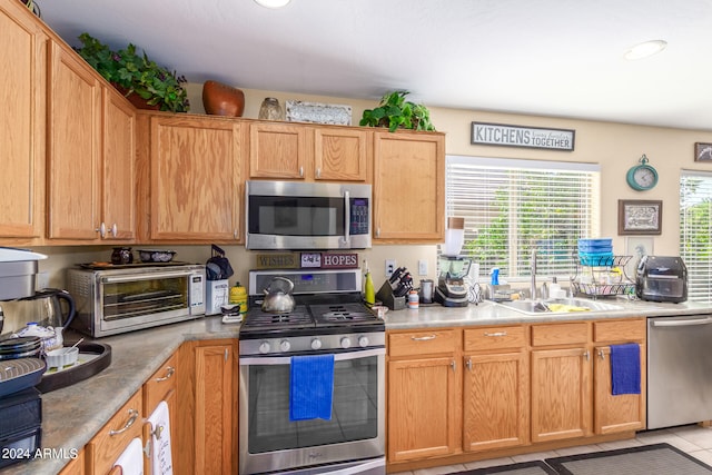 kitchen with stainless steel appliances, sink, and light tile patterned floors