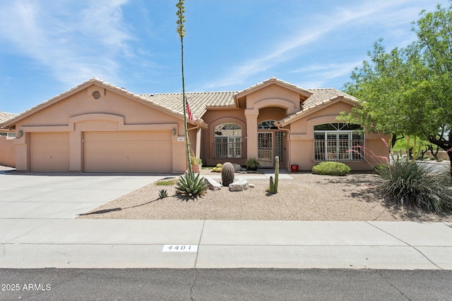 4401 E Barwick Dr, Cave Creek, AZ 85331 - mediterranean / spanish-style house with an attached garage, stucco siding, a tiled roof, and concrete driveway