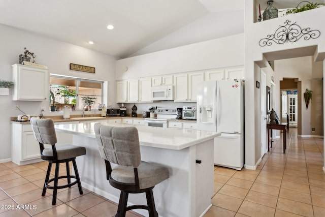 4401 E Barwick Dr, Cave Creek, AZ 85331 - kitchen featuring white appliances, light tile patterned floors, high vaulted ceiling, a kitchen island, and white cabinets