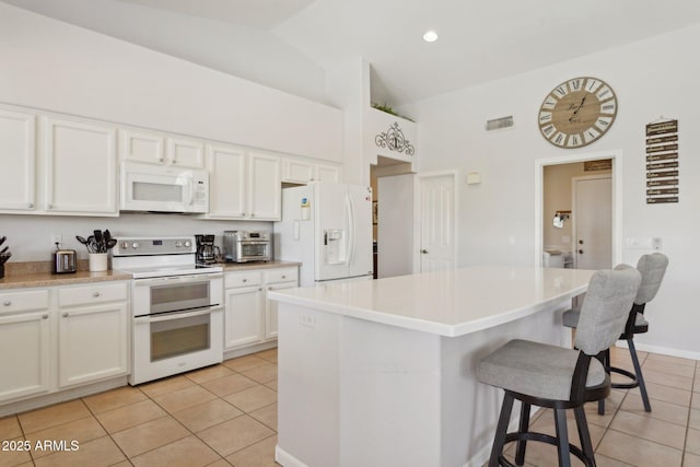 4401 E Barwick Dr, Cave Creek, AZ 85331 - kitchen featuring white appliances, light tile patterned floors, high vaulted ceiling, a breakfast bar area, and a center island