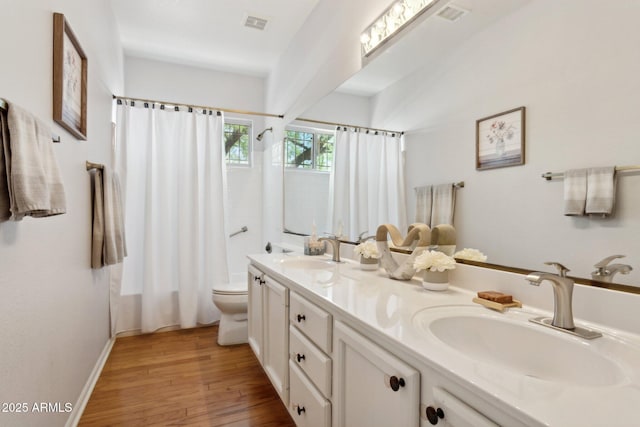 4401 E Barwick Dr, Cave Creek, AZ 85331 - bathroom featuring toilet, wood finished floors, double vanity, shower / bath combo with shower curtain, and baseboards