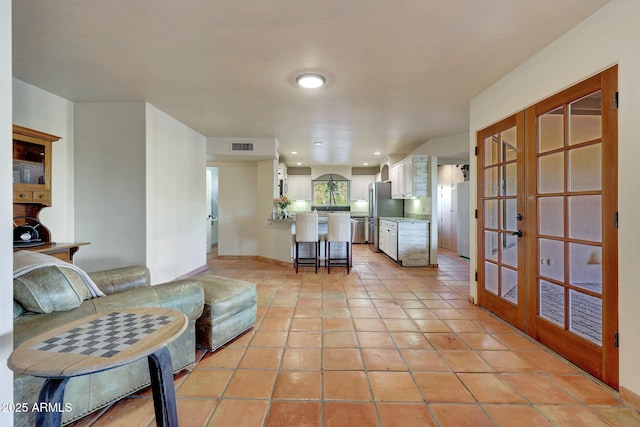 living room featuring french doors and light tile patterned floors