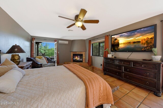 bedroom with a wall unit AC, light tile patterned flooring, multiple windows, and access to exterior