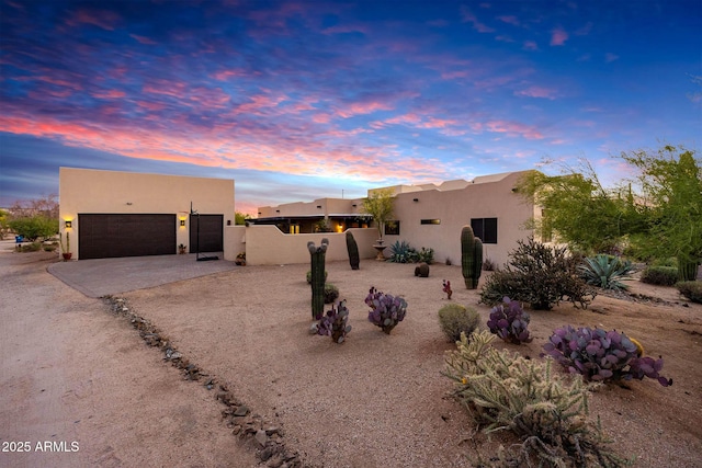 pueblo-style house with stucco siding and driveway