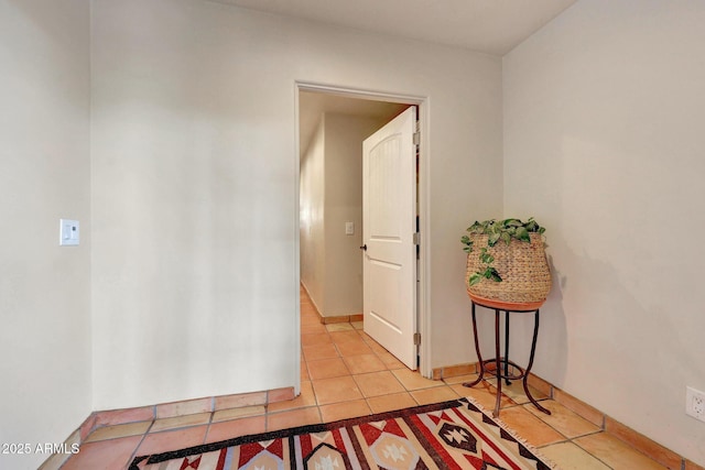 corridor featuring light tile patterned floors and baseboards