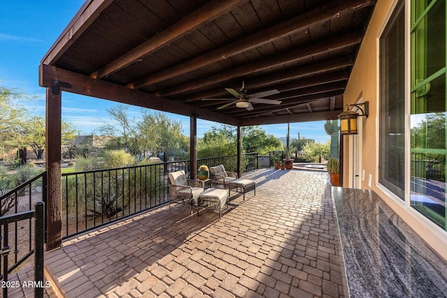 view of patio / terrace with ceiling fan and an outdoor hot tub