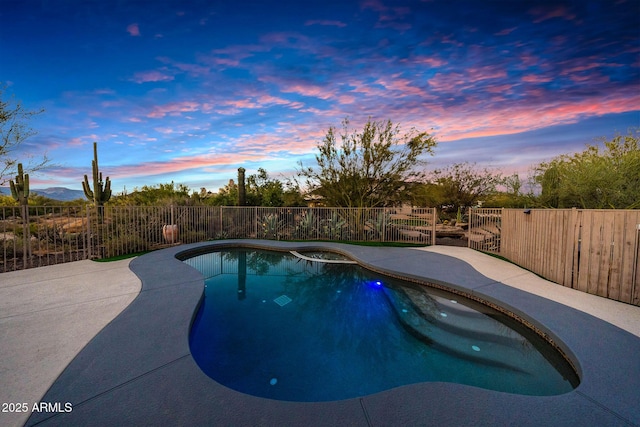 pool at dusk featuring a fenced backyard and a patio area