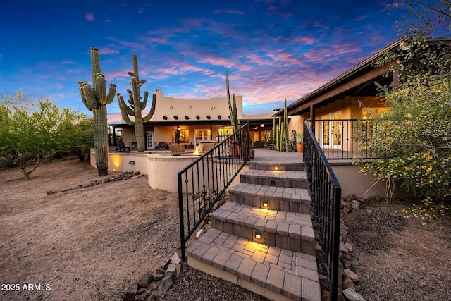 back of house with a patio, stucco siding, and stairway