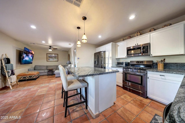 kitchen featuring stainless steel appliances, open floor plan, white cabinetry, recessed lighting, and ceiling fan