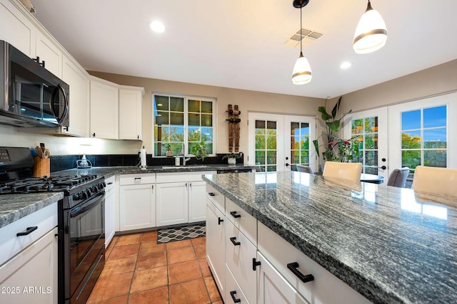 kitchen featuring gas stove, french doors, white cabinetry, and recessed lighting