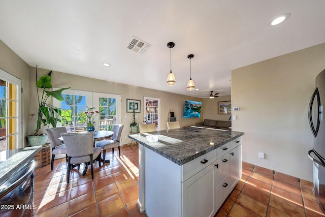 kitchen with white cabinets, a ceiling fan, dishwasher, pendant lighting, and freestanding refrigerator
