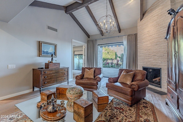 living room featuring a fireplace, beamed ceiling, light hardwood / wood-style flooring, and high vaulted ceiling