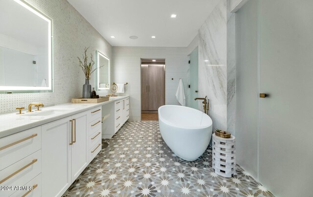 bathroom with tile floors, vanity, and a bathing tub