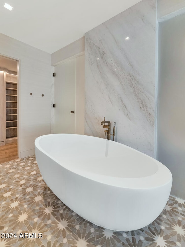 bathroom featuring tile flooring and a bath to relax in