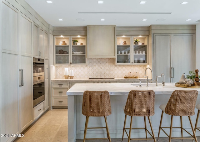 kitchen featuring sink, gas stovetop, tasteful backsplash, and light tile floors