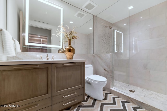 bathroom featuring tile walls, a shower with shower door, tile floors, toilet, and vanity