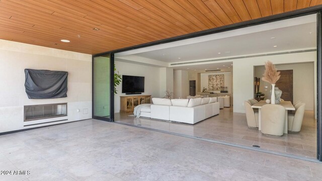 unfurnished living room featuring wooden ceiling and tile floors