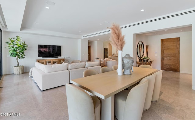 dining area featuring light tile flooring and a raised ceiling