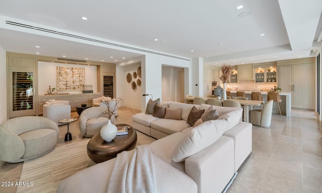 living room with sink, light tile floors, and a raised ceiling