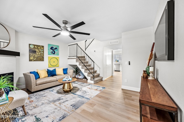 living room with light wood-type flooring and ceiling fan