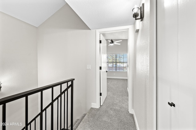 hall featuring light carpet and vaulted ceiling