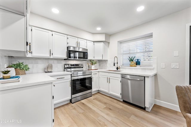 kitchen featuring white cabinets, light hardwood / wood-style floors, appliances with stainless steel finishes, and sink