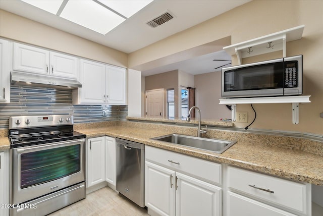 kitchen with stainless steel appliances, sink, tasteful backsplash, and white cabinetry