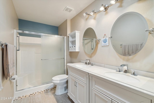 bathroom with toilet, an enclosed shower, and vanity