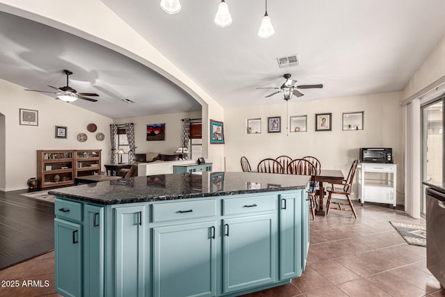kitchen with lofted ceiling, tile patterned flooring, visible vents, ceiling fan, and blue cabinetry