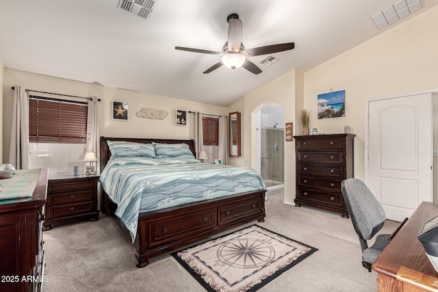 bedroom featuring light colored carpet, visible vents, and arched walkways