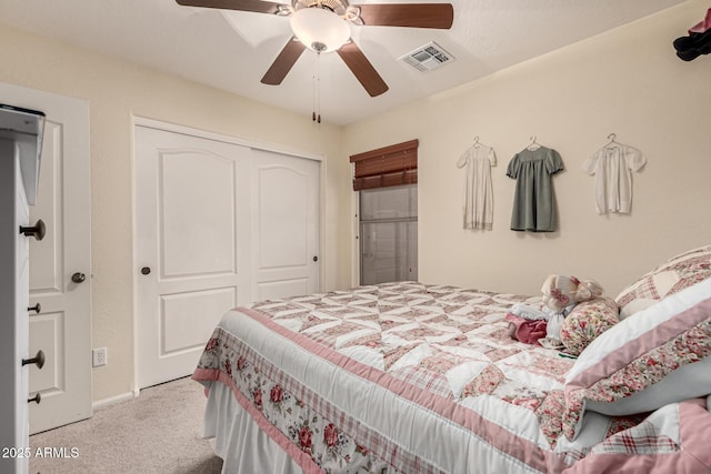 carpeted bedroom with a ceiling fan, a closet, and visible vents