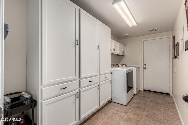washroom featuring baseboards, cabinet space, visible vents, and independent washer and dryer