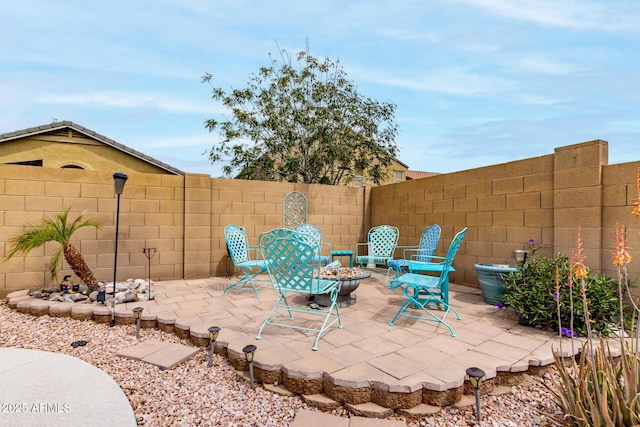 view of patio featuring a fenced backyard and an outdoor fire pit