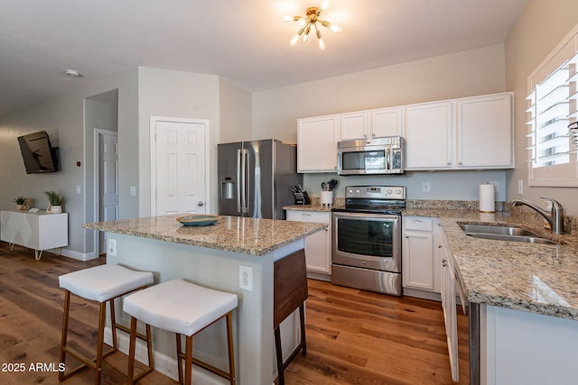 1702 W Wildwood Dr, Phoenix, AZ 85045 - kitchen featuring white cabinets, a breakfast bar, appliances with stainless steel finishes, dark wood-style flooring, and a sink