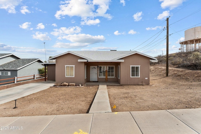 ranch-style house with a shingled roof and fence