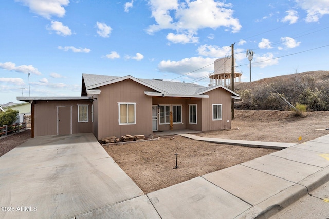 ranch-style home featuring a shingled roof and fence