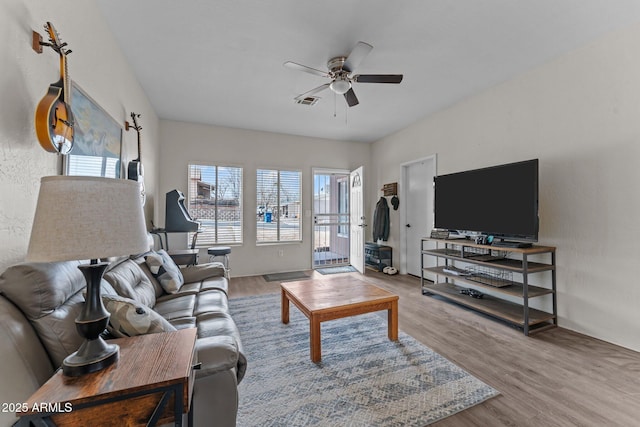 living area with a ceiling fan, visible vents, plenty of natural light, and wood finished floors