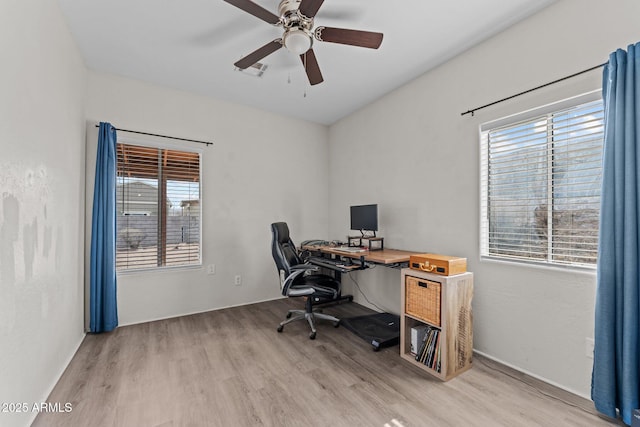 home office with light wood-style floors, visible vents, plenty of natural light, and a ceiling fan