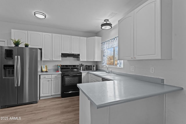 kitchen featuring appliances with stainless steel finishes, a peninsula, under cabinet range hood, white cabinetry, and a sink