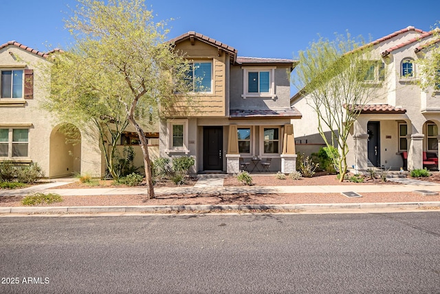 view of property with stucco siding and a tile roof