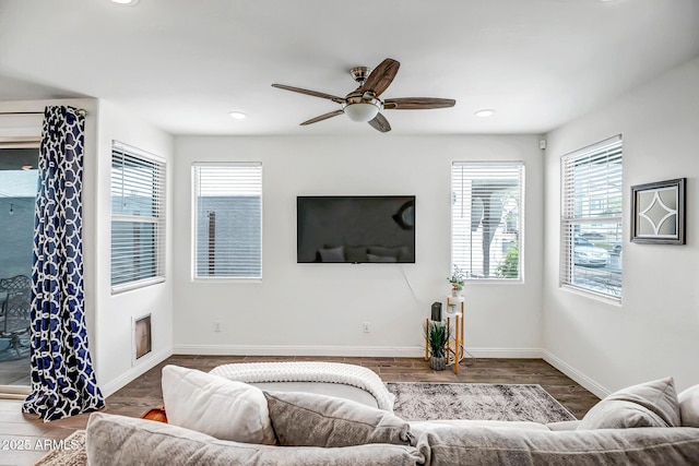 living area featuring baseboards, plenty of natural light, and wood finished floors