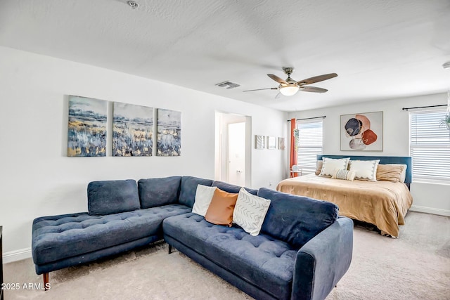 bedroom featuring visible vents, light colored carpet, a ceiling fan, and baseboards