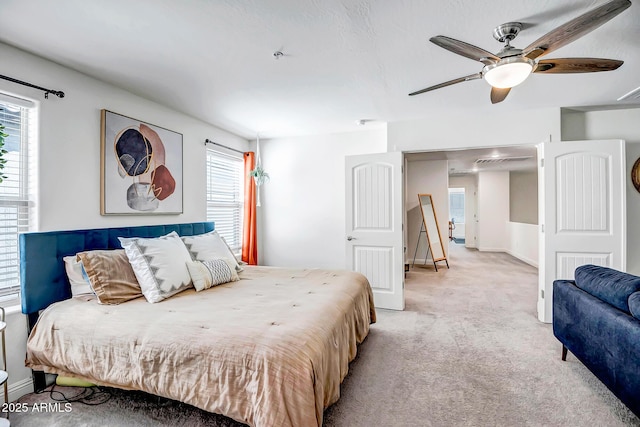 bedroom featuring light colored carpet, baseboards, and ceiling fan