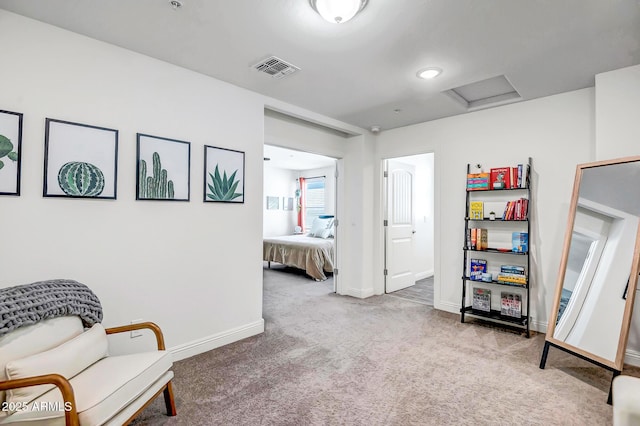 sitting room with visible vents, baseboards, carpet, and attic access