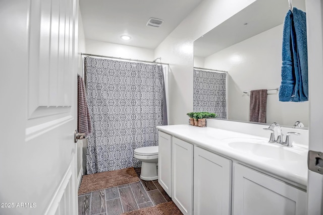 full bath with visible vents, wood tiled floor, toilet, a shower with curtain, and vanity