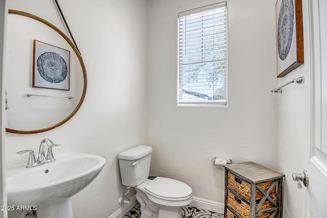 bathroom with a sink, baseboards, and toilet