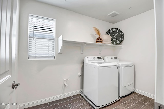 laundry room with laundry area, washer and clothes dryer, baseboards, and wood tiled floor