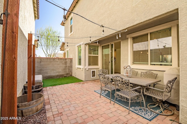 view of patio featuring outdoor dining area and fence